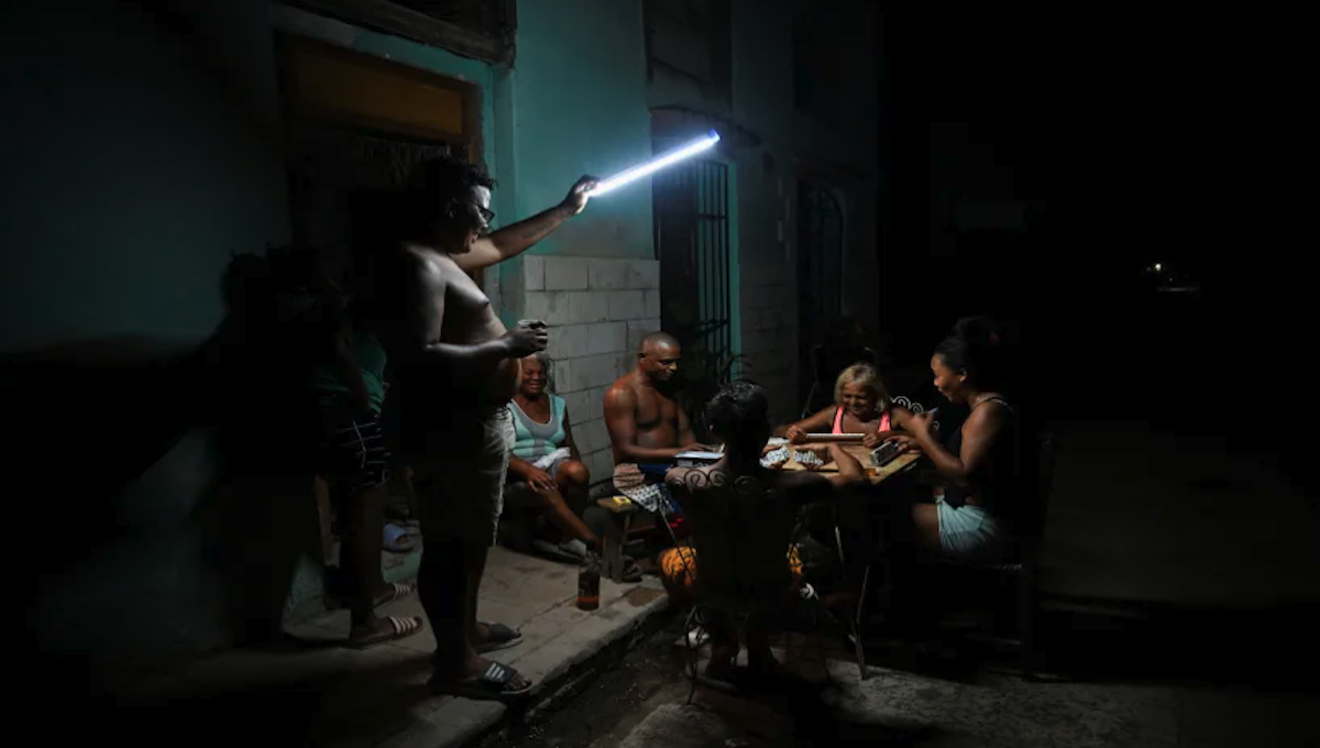 People play domino on the street during a blackout in Havana 