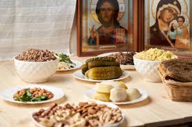 Orthodox Christians attending a Great Lent Presanctified Liturgy with candles in a darkened church