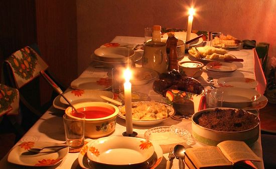 Orthodox faithful holding candles in prayer during a fasting season evening service