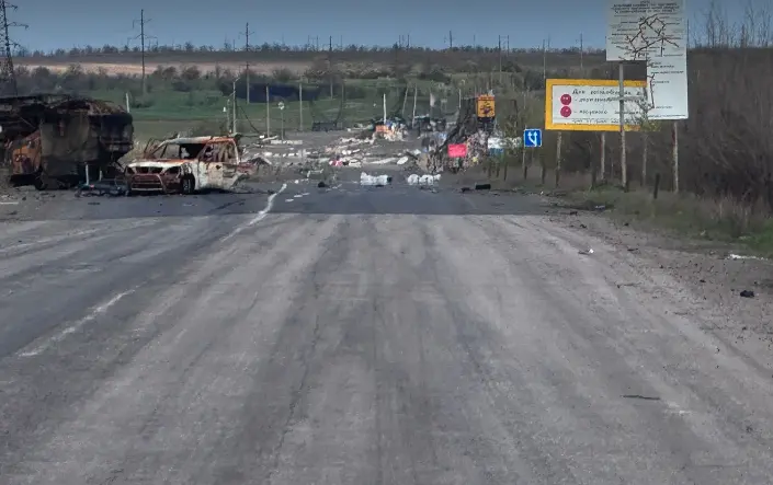 Wreckage of vehicles and debris on the Pavlohrad-Pokrovsk road next to the Donetsk Oblast stele at a checkpoint destroyed by a Russian airstrike, April 28, 2026